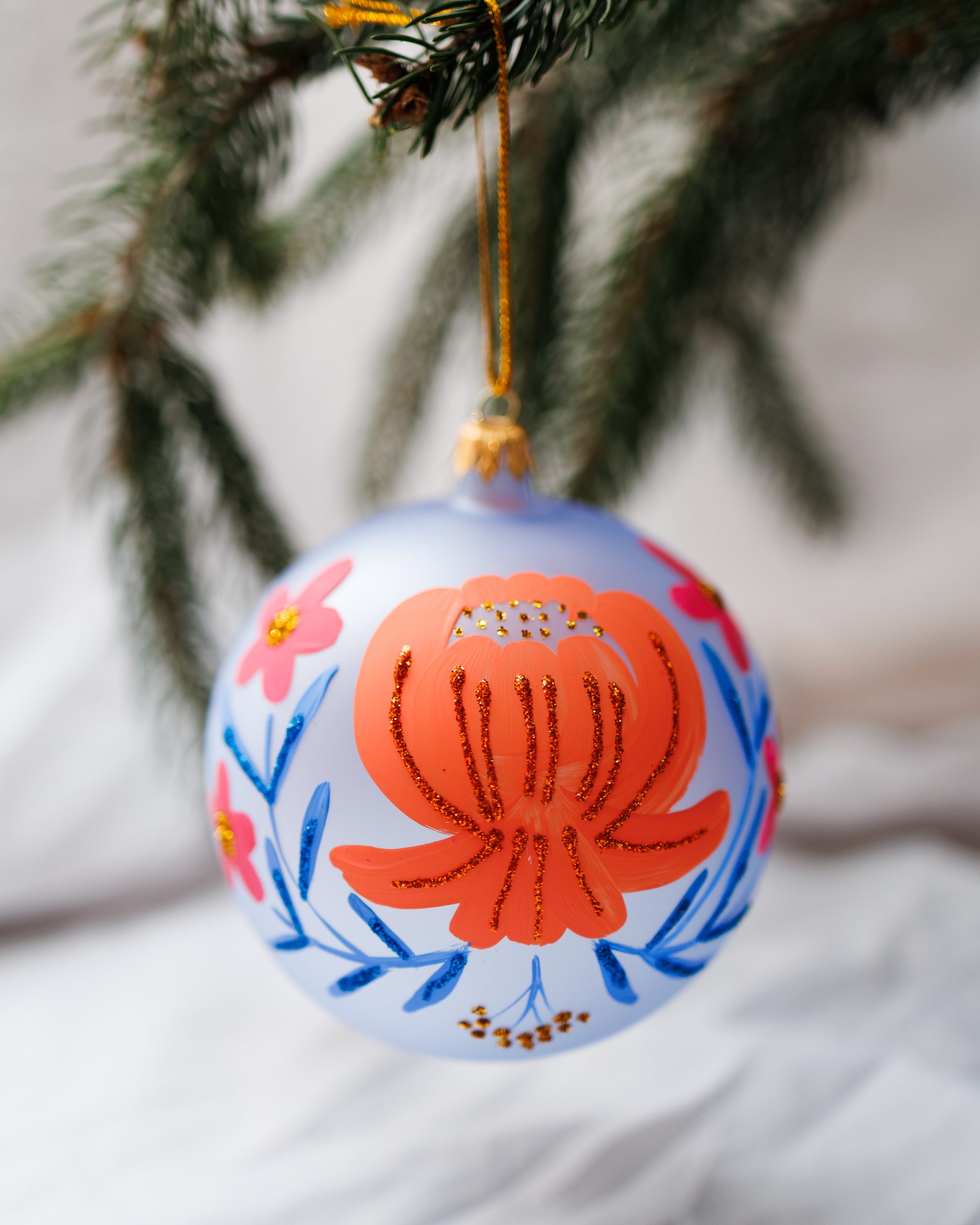 Bombka błękitna w pomarańczowe i różowe kwiaty 12cm